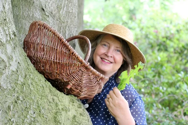Claudia Mönch sammelt Wildpflanzen an einem Baum